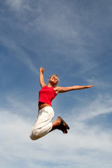 Fototapeta na wymiar happy woman jumping against blue sky