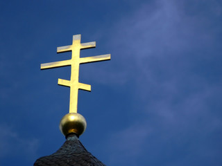 golden orthodox cross on blue sky