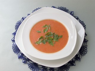 tomatoes soup with green vegetable leaves