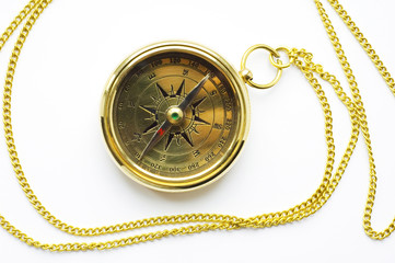 old style gold compass with chain on white backgro