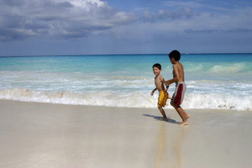 Fototapeta na wymiar niños corriendo en la playa