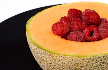 cantaloupe with rasperries on plate
