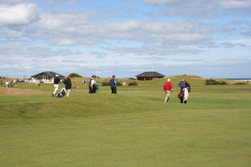 golfers walking across golf course