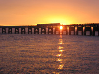 Fototapeta na wymiar train crossing Tay Rail Bridge o zachodzie słońca, dundee szkocja