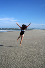 woman jumping and running on beach