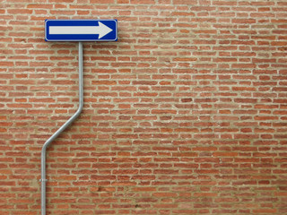 one way sign over a bricks wall