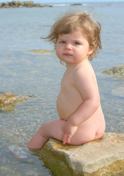 Enfant nu assis pieds dans l'eau Stock Photo | Adobe Stock