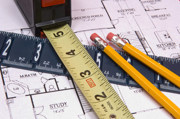 measuring tape and ruler with pencils on house floorplan