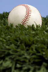 baseball on grass with blue sky
