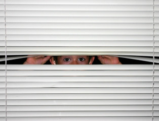 boy peeking through blinds