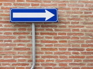 one way sign over a bricks wall
