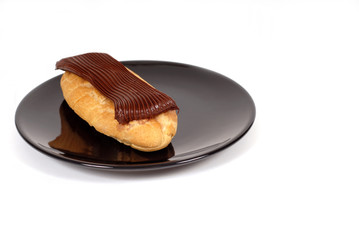 chocolate eclair on black plate
