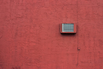 red stucco wall with air conditioning unit
