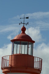 un beau phare rouge avec sa belle girouette