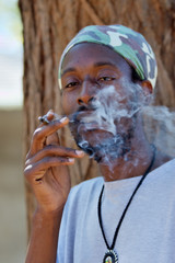rastafarian man smoking marijuana
