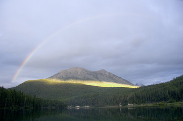 rainbow over the alces lake in the break of dawn