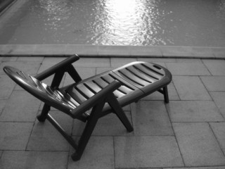chaise longue sur terrasse au bord de la piscine