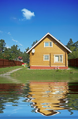 wooden house reflecting in the water