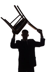 silhouette of man with chair over his head