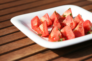 tomatoes with basil on white plate