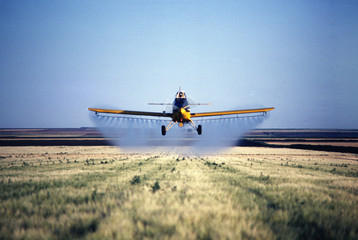 Naklejka premium spray plane spraying barley field in colorado