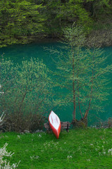 a red and white canoe resting by the river