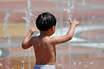 the conductor - young boy playing in fountain