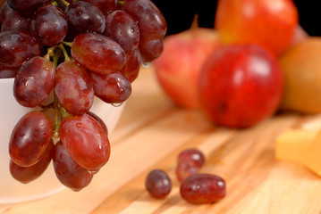close up view of delicious fruit and cheese on cutting board