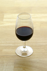 glass of port on butcher block surface