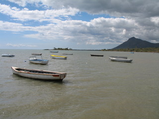 Fototapeta na wymiar barques sur lagon et montagne en fond