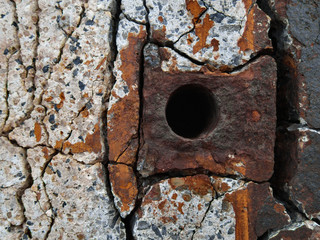 rusty metal element in concrete wall
