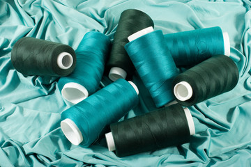 green bobbins of threads on green cloth