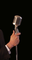 singer holding vintage microphone & stand
