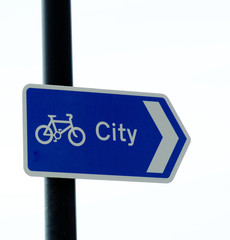 cycle way sign pointing towards city on white back