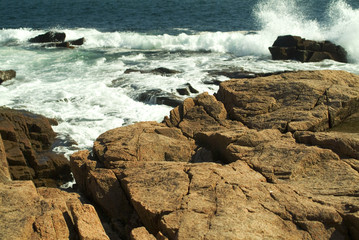 Fototapeta na wymiar large waves crashinng onto pink granite coast