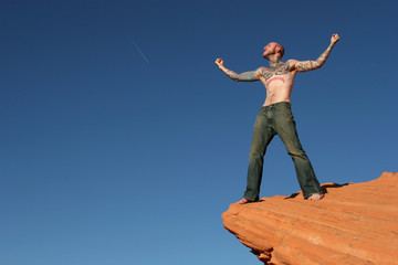 tattooed man on red rocks