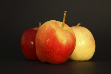 three apples on black background