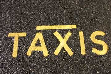 yellow taxi sign on black tarmac