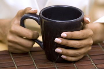 hands holding cup of coffee