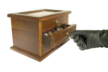 hand in black glove opening casket with jewelry