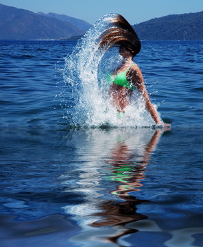 girl in the sea jumping from the water