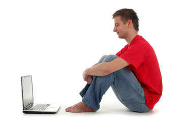 young man sitting on floor with laptop