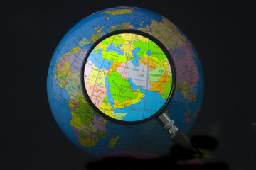 Obraz premium Map of middle east on globe seen through magnifying glass