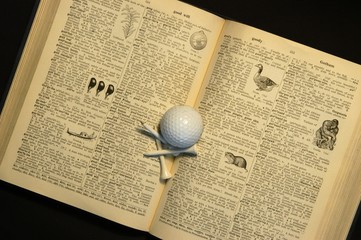 dictionary, golf ball and tees
