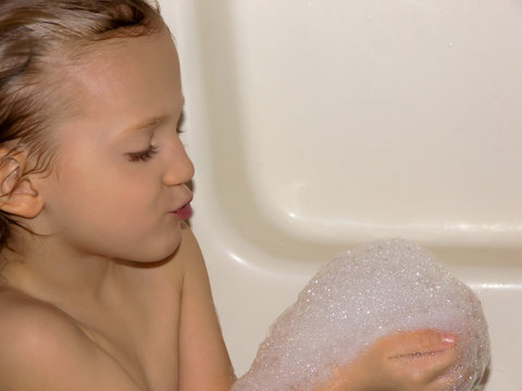 girl blowing bath bubbles