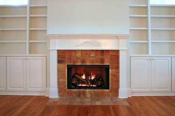 lit fireplace with built in bookshelves