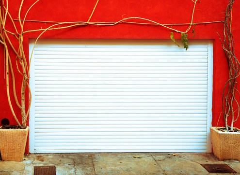 Bright Orange Wall With A White Garage Door