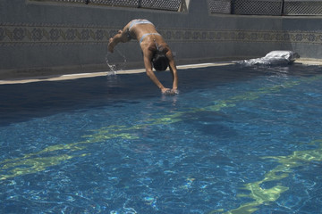 Girl jumping to swiiming pool © Robert Wróblewski