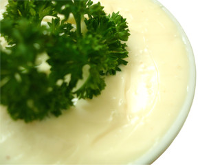 mayonnaise in sauce-boat with curly parsley twig
