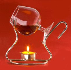 glass with cognac and candles